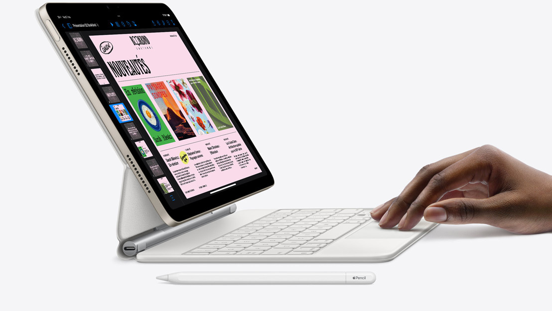 Vue latérale d’un iPad Air montrant l’app Keynote, fixé à un Magic Keyboard avec une main posée sur le trackpad et un Apple Pencil posé à côté.
