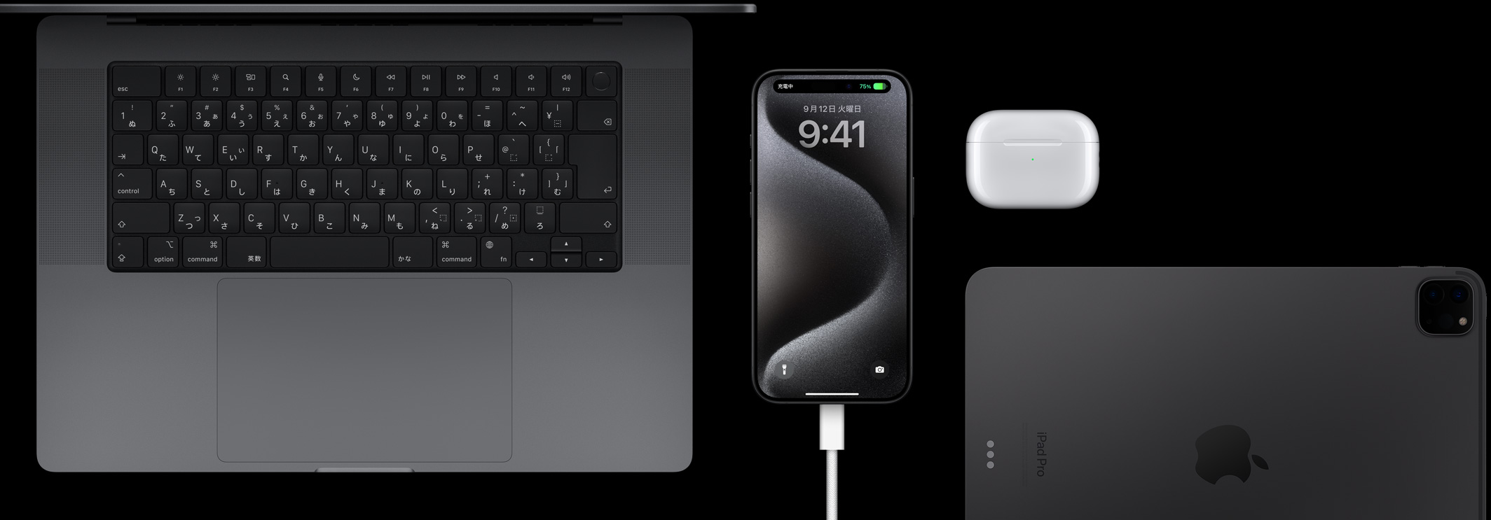 USB-CコードをつないだiPhone 15 Pro。MacBook Pro、AirPods Pro、iPadが周りに置かれている