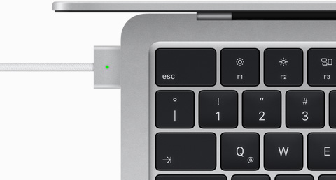 Imagen desde arriba de un cable MagSafe conectado a una MacBook Air color plata