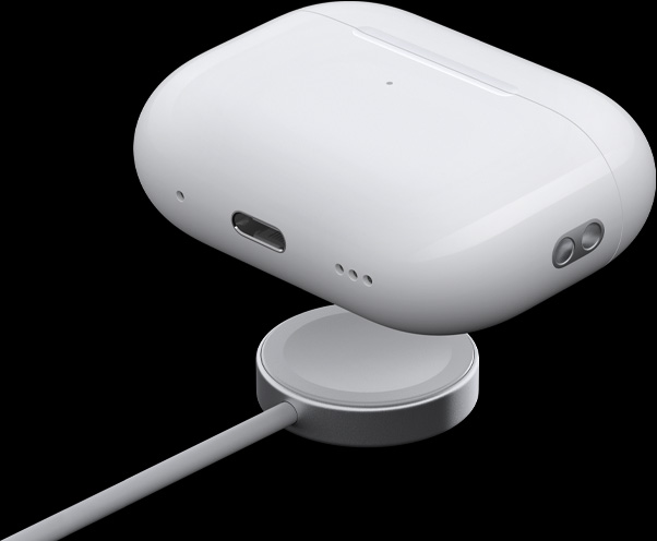 Skrå visning av ladeetuiet med MagSafe hvor høyttaleren, sporfestet og USB-C-portet vises. Etuiet svever over en ladeplate til en Apple Watch.