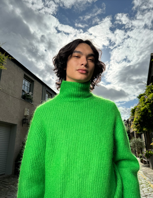 La foto di una persona scattata con iPhone 15 Pro che evidenzia il colore brillante del suo maglione e i toni accurati della pelle