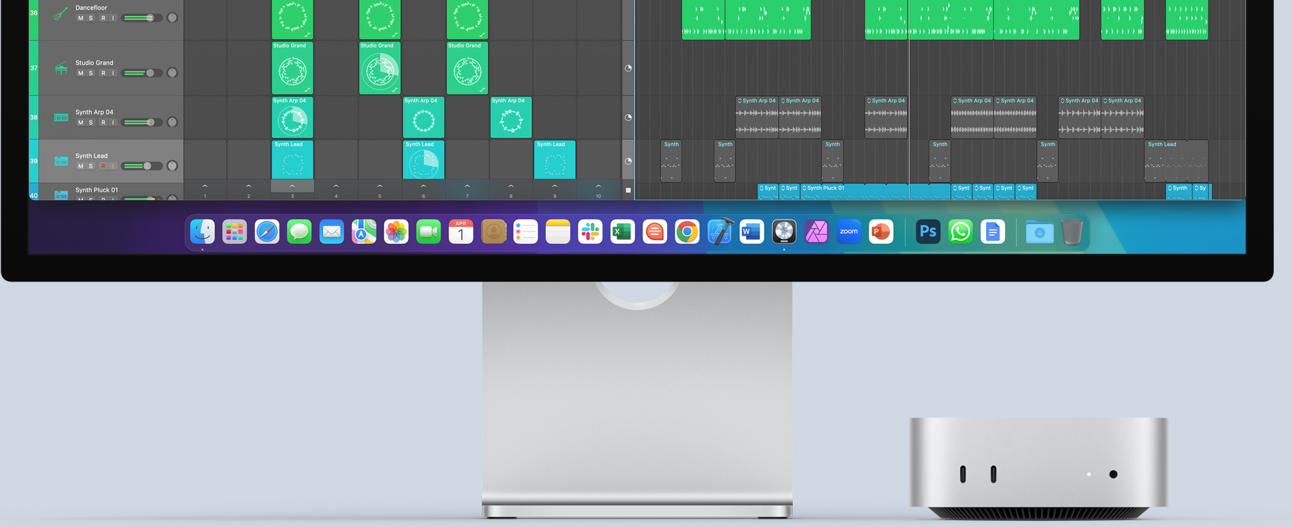 Vista frontal de una Mac mini con puertos delanteros y luz de encendido, que se acomoda perfectamente debajo de un monitor Mac con una pantalla colorida e íconos de apps en el Dock