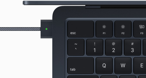 Pogled odozgo na punjač MagSafe priključen na MacBook Air u ponoćno crnoj boji