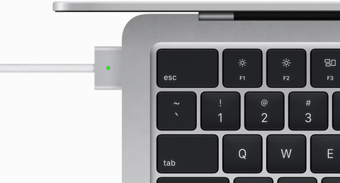 Vedere de sus a cablului MagSafe conectat la un MacBook Air în culoarea Argintiu