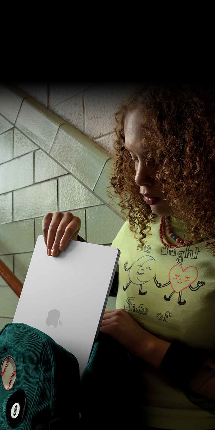 A person putting their MacBook Air into a backpack