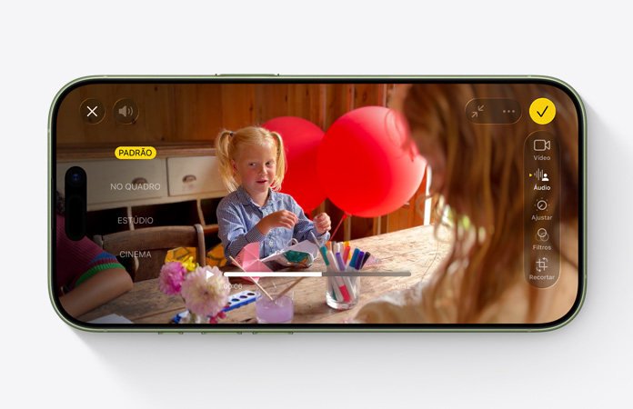 Parte da frente do iPhone 17, vídeo com o recurso Mixagem de Áudio em uso, mostrando uma criança brincando em uma mesa com balões