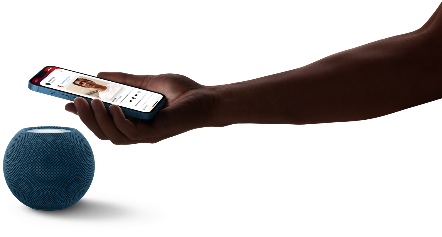 Image de la main d’une personne tenant un iPhone au-dessus d’un HomePod mini bleu. Lecture de musique en cours sur l’écran du téléphone.
