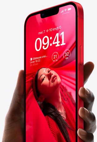 A hand holding iPhone 14 in Red with a personalized Lock Screen featuring a photo of person dressed in all red, the time, and widgets