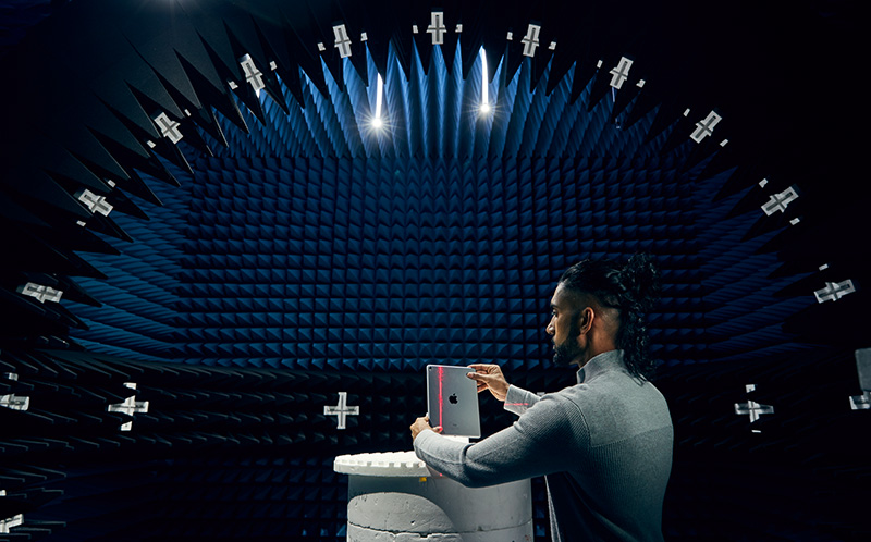 An engineer tests an Apple product in an antenna chamber