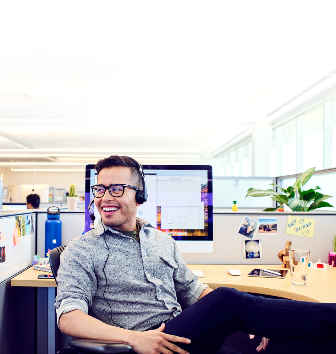 Un Apple Support Advisor se détend entre deux appels dans son bureau, sur le campus Apple.