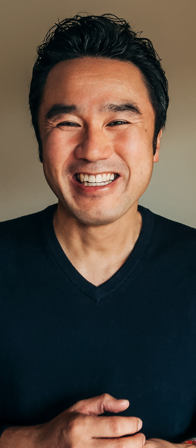 Fotoportrett av Tetsu, som smiler bredt og ser mot leseren.