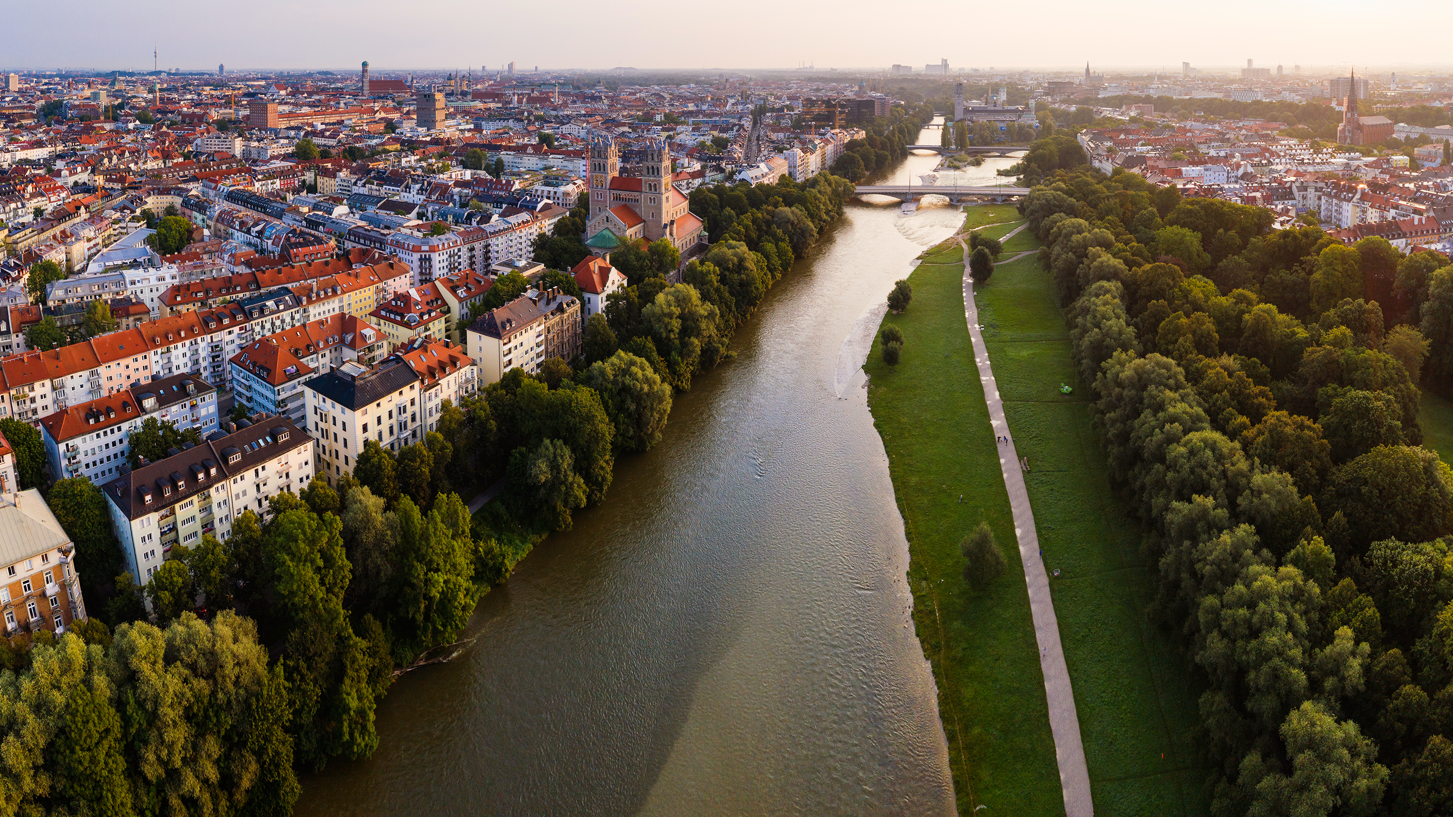 Vue aérienne de Munich montrant une rivière, des arbres et un sentier pédestre longeant la rivière.