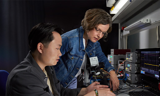 Ruth a colaborar com um colega em tecnologia de processador numa bancada de laboratório.