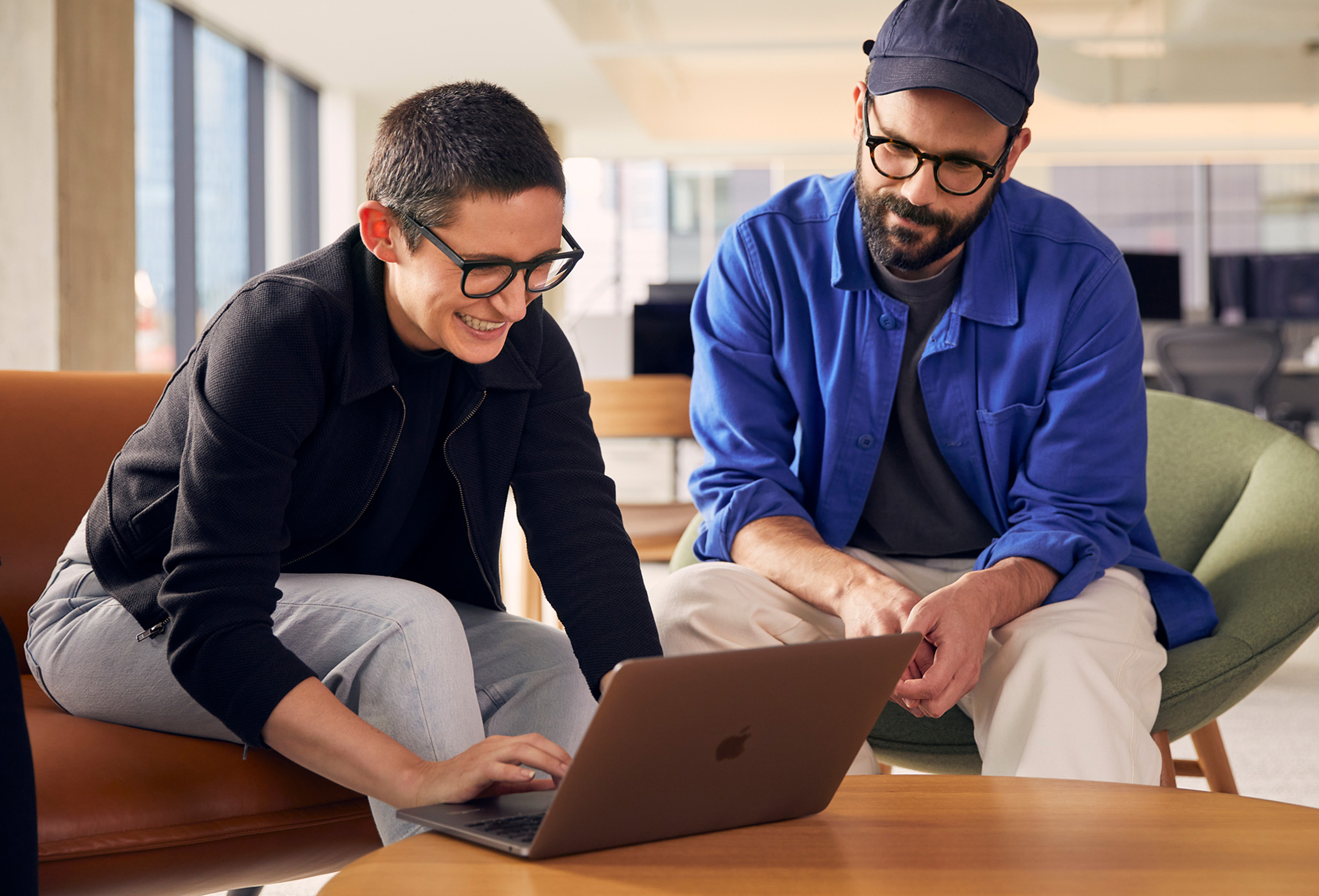 Två Apple-medarbetare samarbetar på en MacBook.