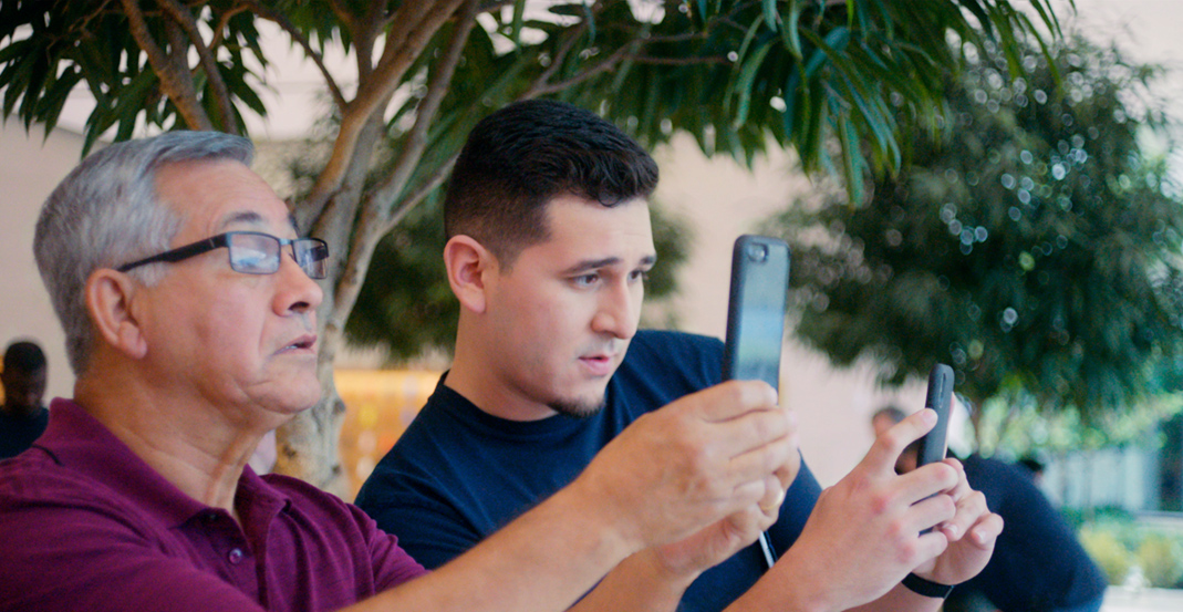 Teknik Uzman Jeronimo, Apple Store’daki bir müşteriye iPhone kamerasının nasıl kullanılacağını gösteriyor.