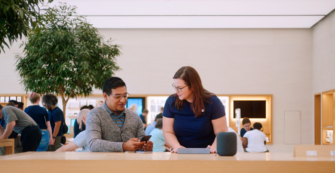 Apple Store’da Genius olarak çalışan Melissa, bir müşteriye iPhone’uyla ilgili sorunun çözülmesi konusunda yardımcı oluyor.