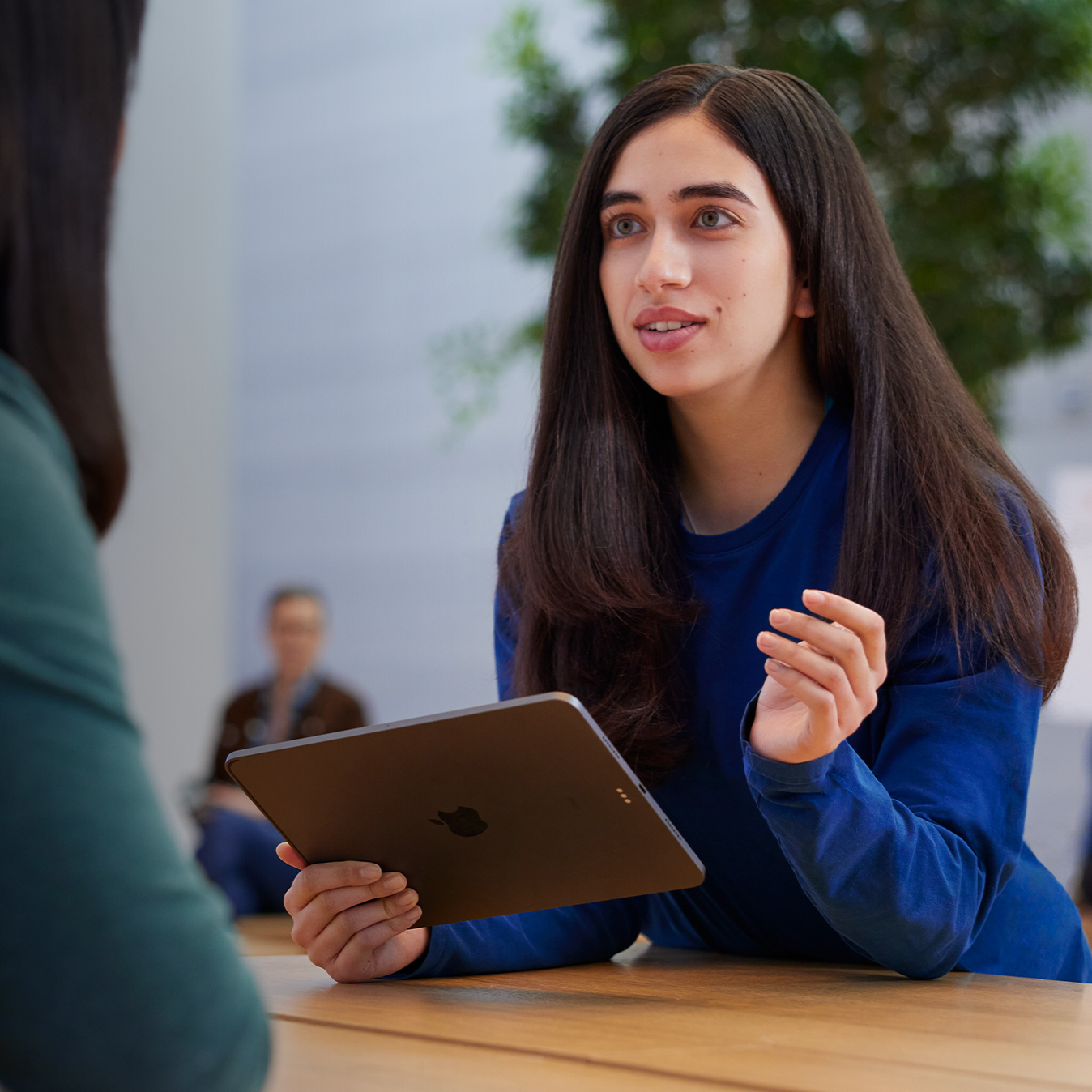 Serene, un iPad à la main, discute avec une cliente.