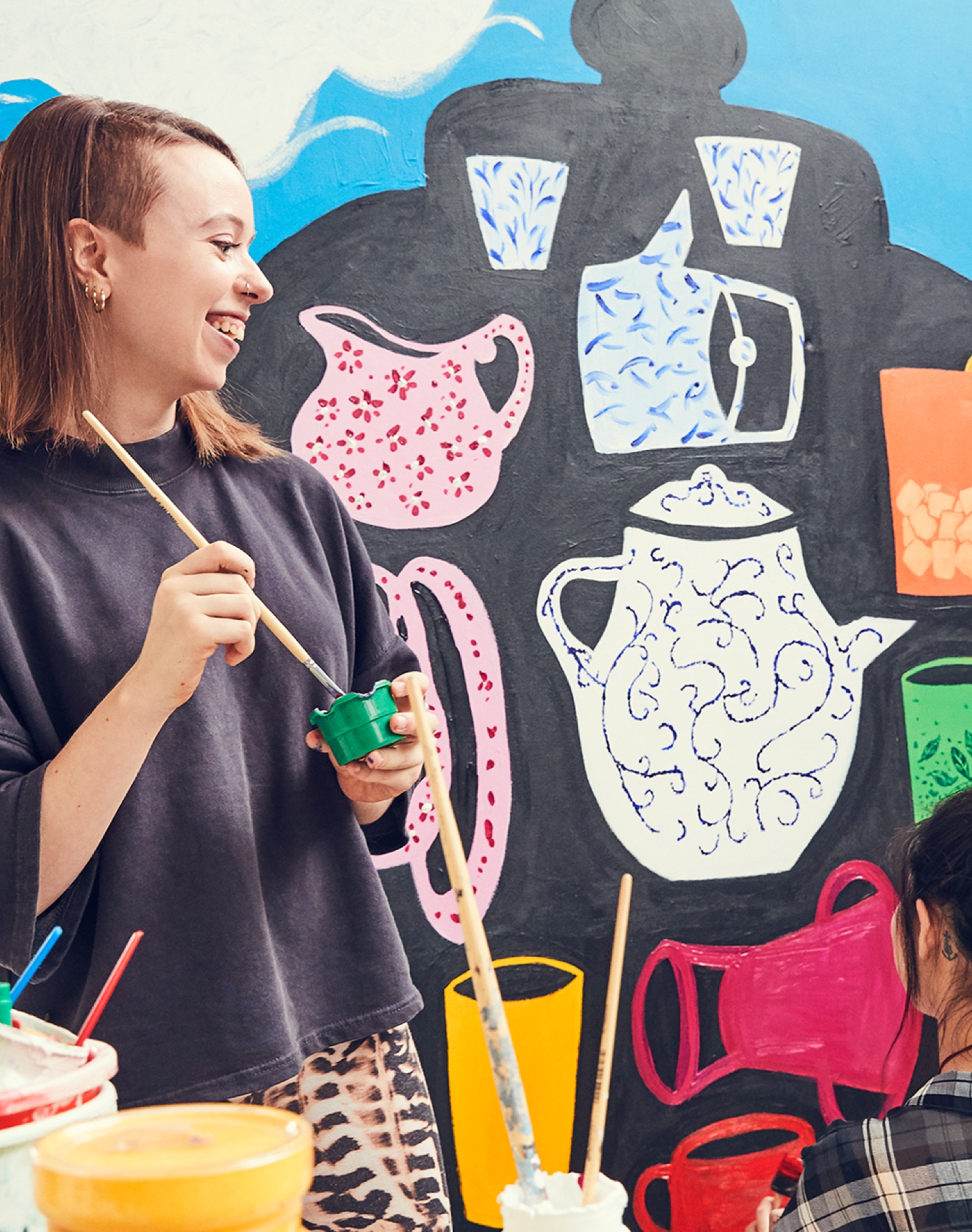 A female Apple Store employee paints a large picture in her home.