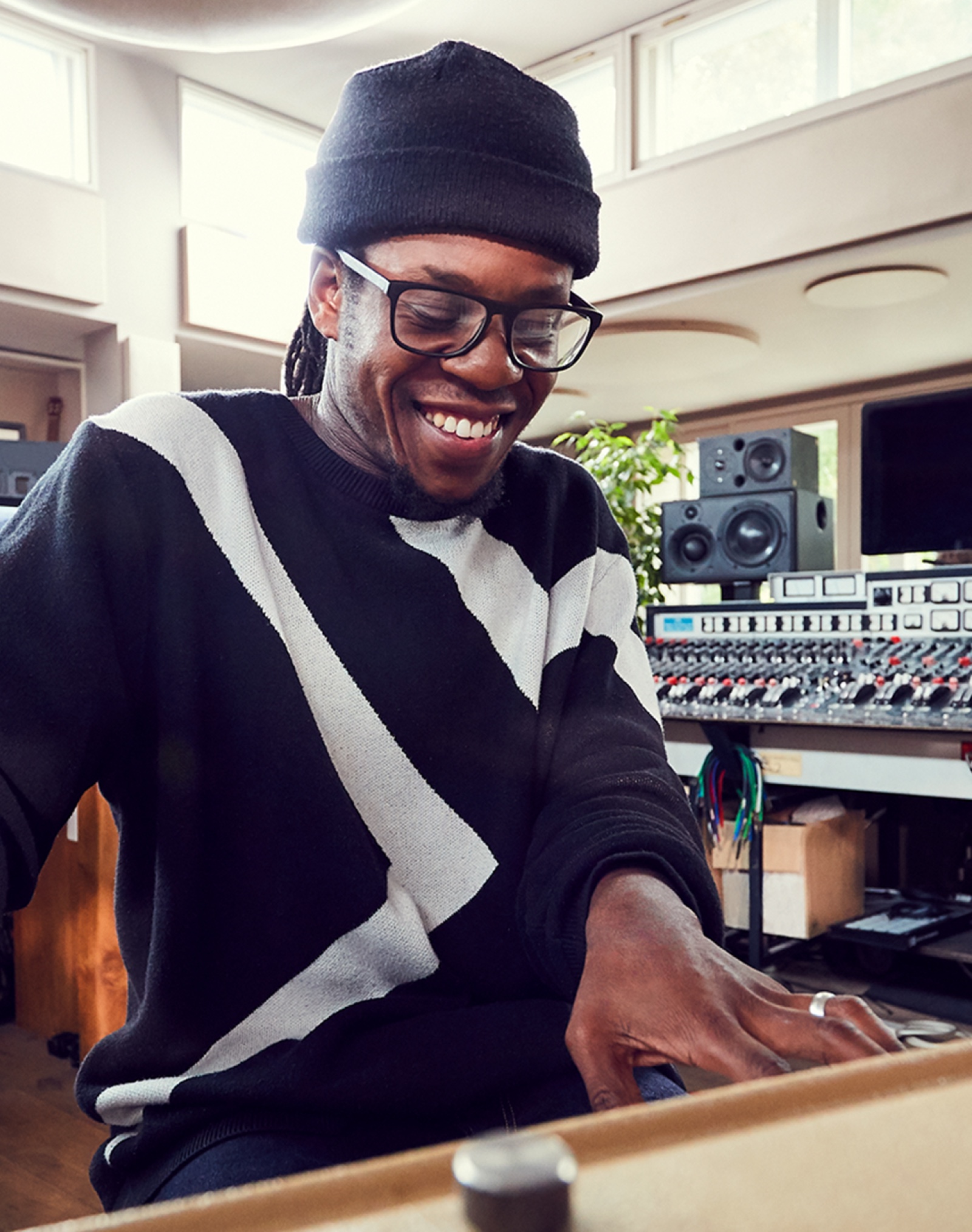 A male Apple Store employee plays keyboards in a professional music studio.