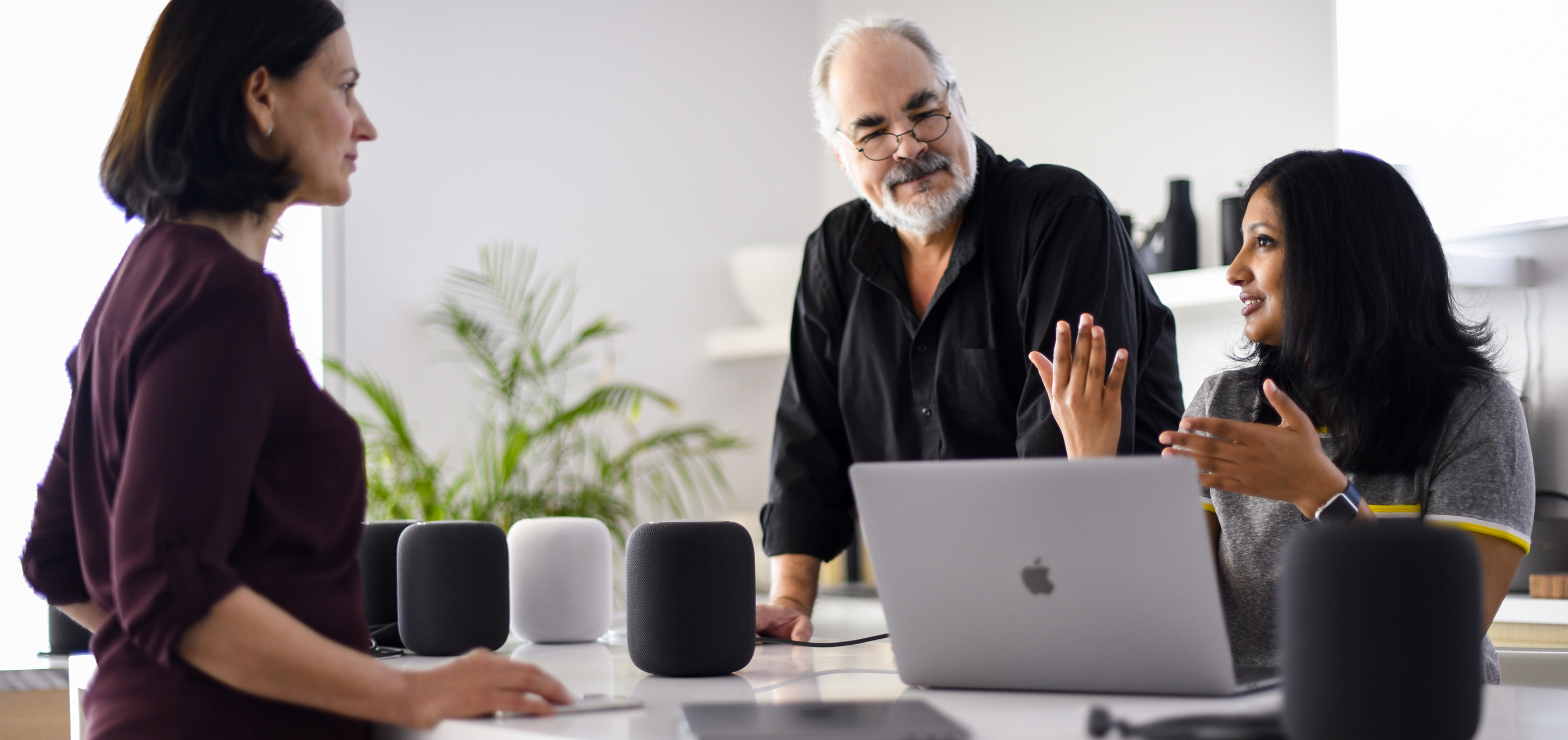 A group of Apple machine learning and AI employees have a conversation in an office.