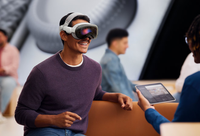 Customer at an Apple Store wearing Apple Vision Pro experiencing a one-on-one demo with a Specialist