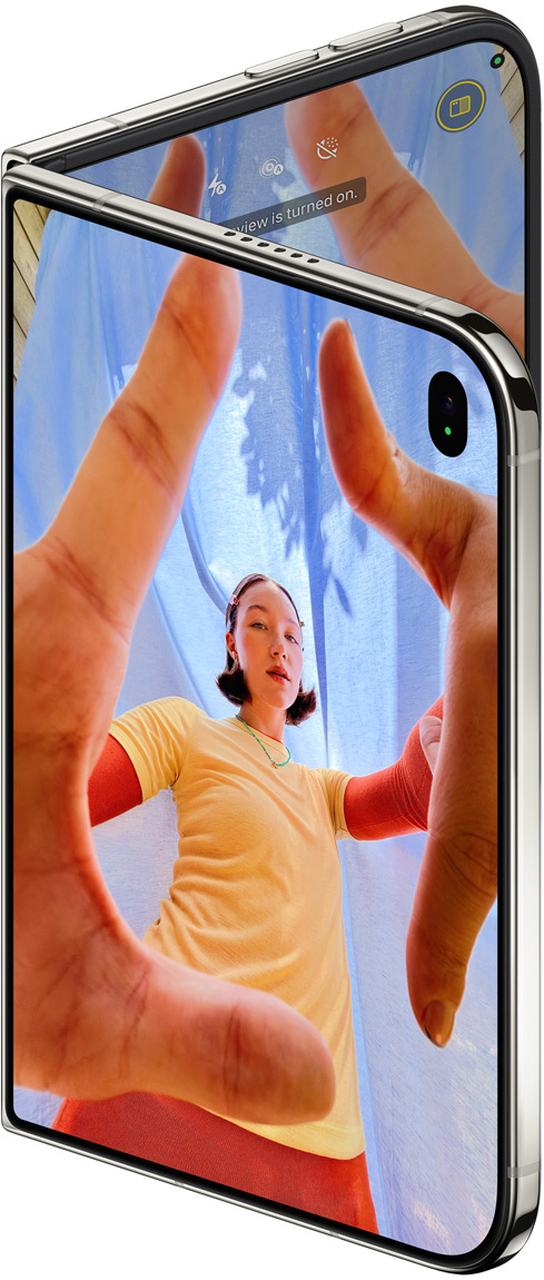 iPhone Duo, Star White color, slightly open, Camera app on outer display with Center Stage front camera, inner display shows Photos app library