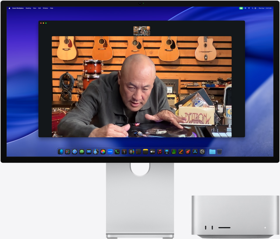 Tijdens een videogesprek op Studio Display XDR met een Mac Studio eronder kijkt iemand in een muziekwinkel naar een draaitafel