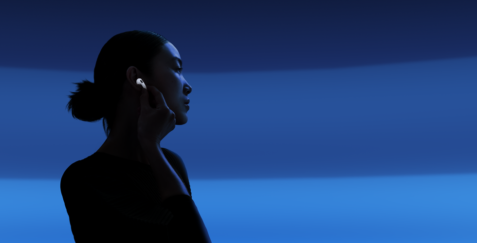 Άτομο που κρατά με τον αντίχειρα και τον δείκτη το στέλεχος των AirPods 5 για να αλλάξει λειτουργία ακρόασης