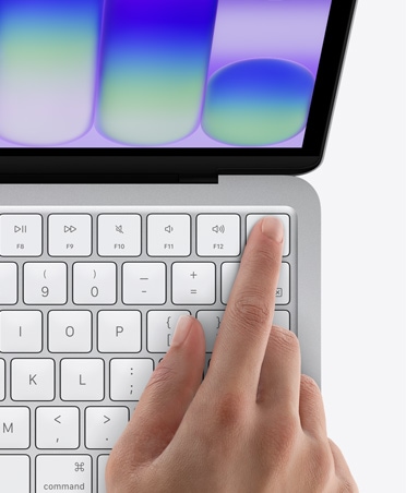MacBook Neo, σε ασημί χρώμα, δάχτυλο ατόμου στον αισθητήρα Touch ID στην επάνω δεξιά γωνία του πληκτρολογίου