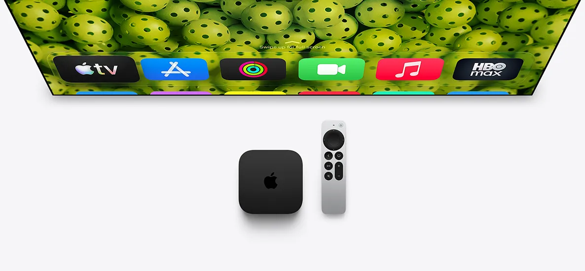 Apple TV 4K 和 Siri Remote 置於電視螢幕下方，螢幕顯示主畫面，展示最高一列的 app 圖示，背景為綠色匹克球