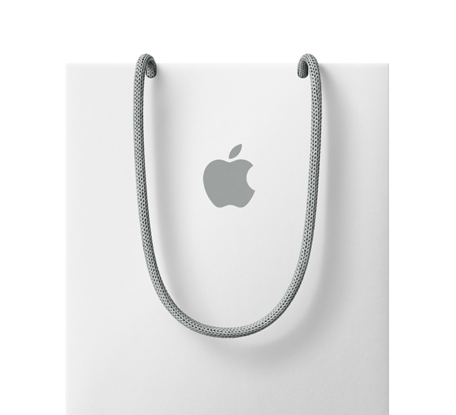 白色禮品袋，中央印有 Apple 標誌，配以灰色穿繩手挽