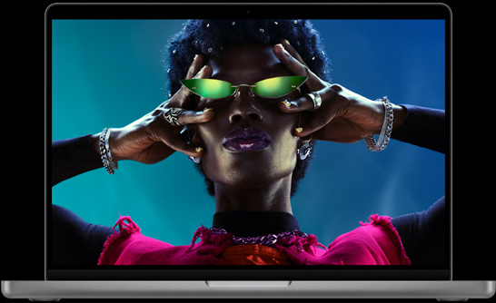打開的銀色 MacBook Pro，顯示器展示一個人身穿銀色衣服