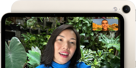 iPad mini elölnézetből, a kijelzőn a fekvő tájolású 12 MP Center Stage előlapi kamera felülete, amelyen valaki videohívást folytat zöld növényzet előtt