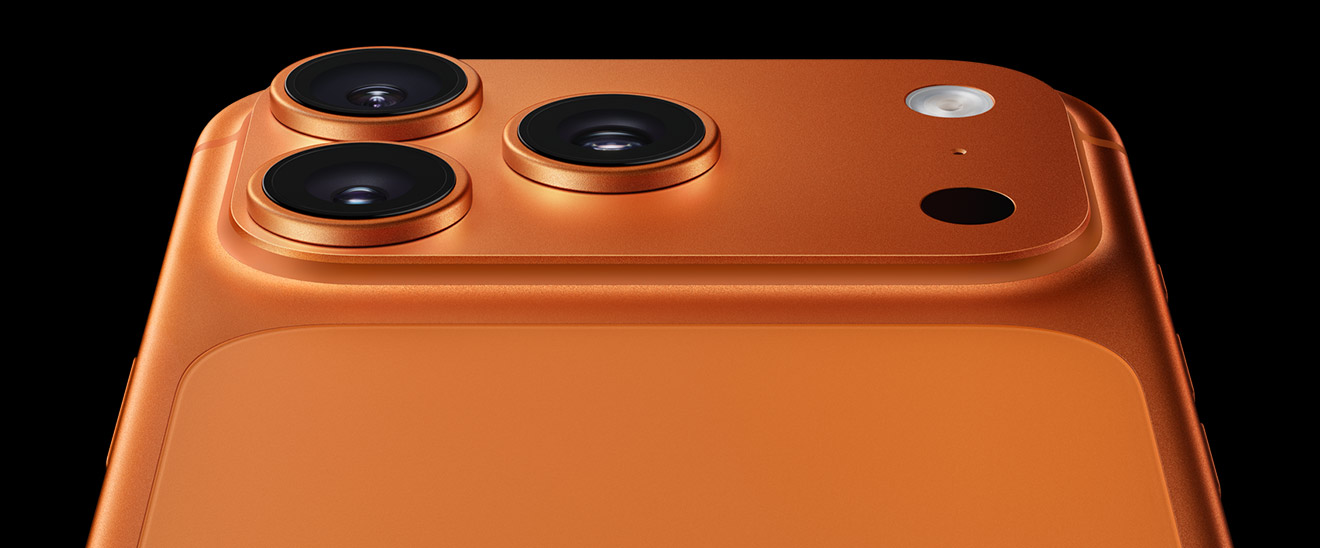 A back view of the top third of an iPhone 17 Pro in Cosmic Orange showing all three 48 MP cameras.