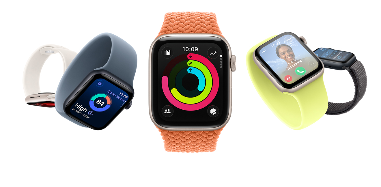 Five Apple Watch SE 3 devices. Left to right: The first in Starlight Aluminum is downward facing. The second in Midnight Aluminum is tilted at a 45 degree angle with the display showing the time and a sleep score. The third Apple Watch SE in Starlight Aluminum in the center of the picture faces front with the display showing the time and other dynamic data. The fourth in Starlight Aluminum is tilted, displaying an incoming call from a picture of a person with a smiling face named Ashley. A fifth image of an Apple Watch SE in Midnight Aluminum displays a side view of the watch face with the temperature, time, and other dynamic data visible. 