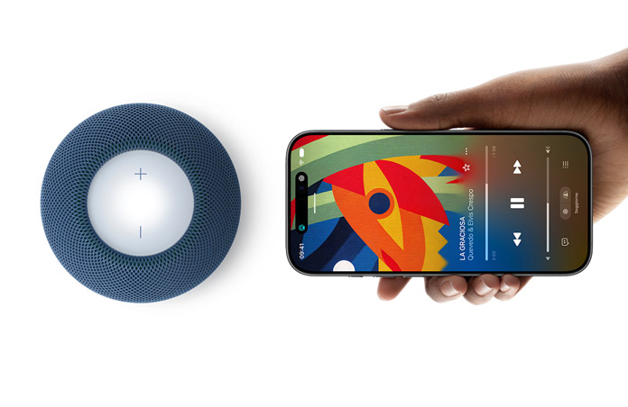 HomePod mini 2 e iPhone: una mano che tiene un iPhone in orizzontale accanto a un HomePod mini 2 blu per la funzione Handoff
