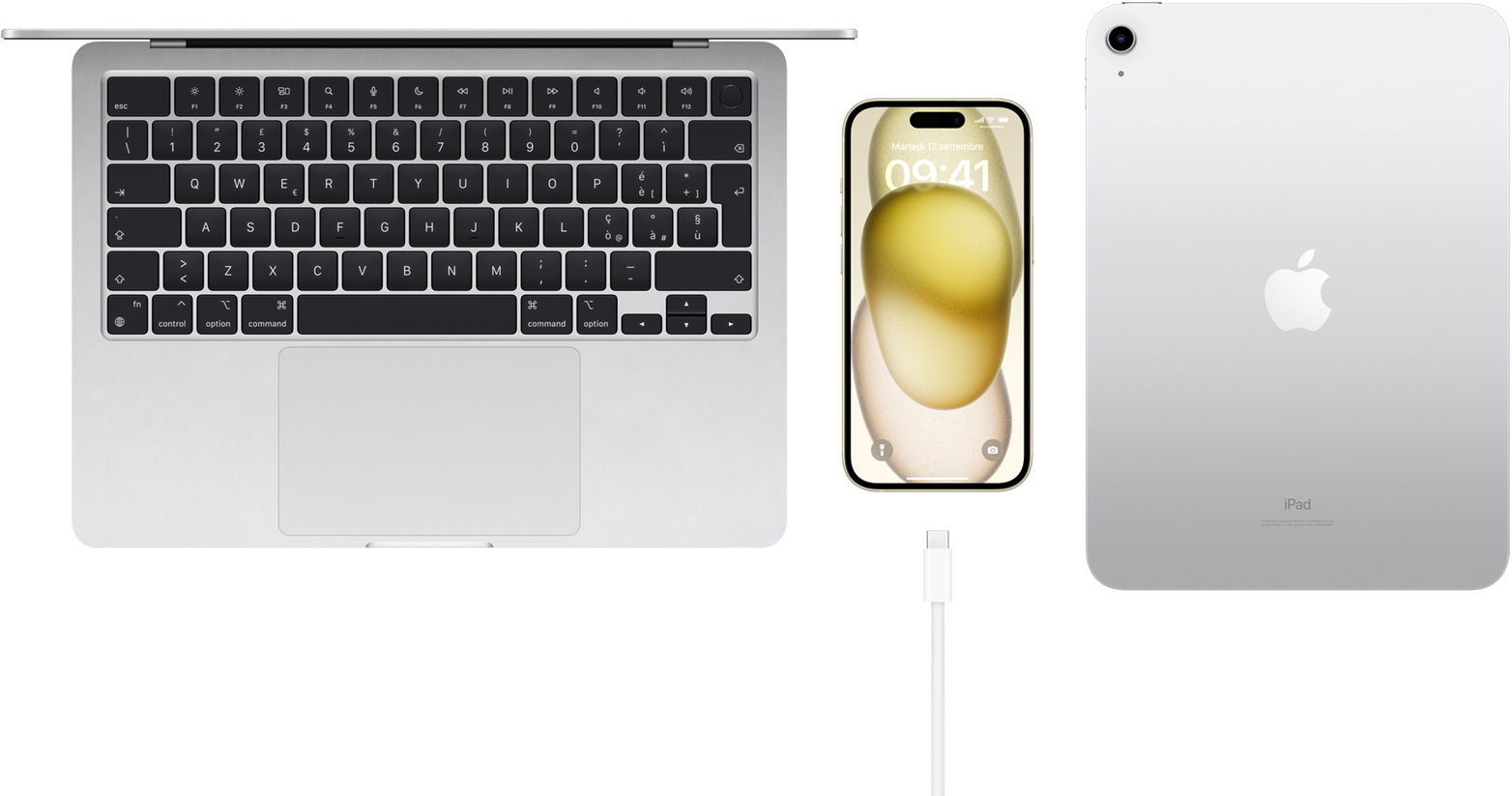 Vista dall’alto di un MacBook Pro, un iPhone 15 con un cavo USB-C, e un iPad