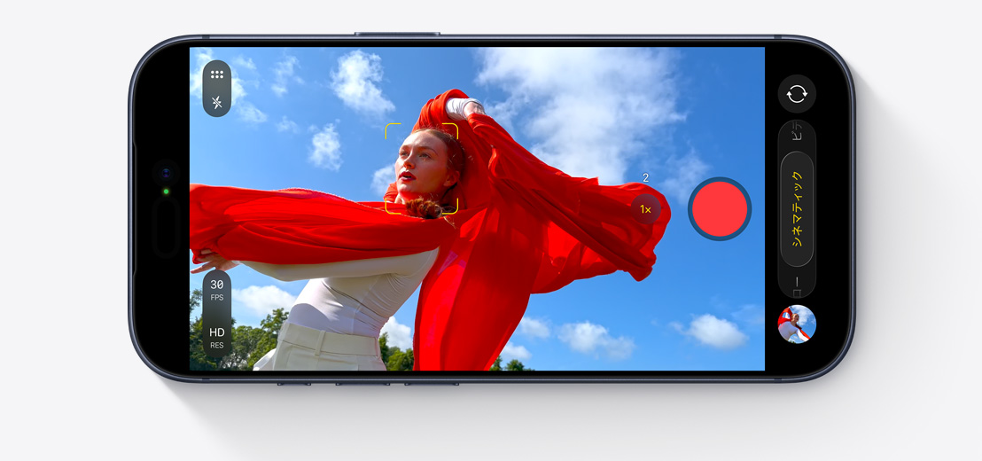横向きのiPhoneの前面の外観。車の中で、センターフレームフロントカメラを使って2人の人物のセルフィービデオを撮影している。それぞれの顔が黄色い四角で囲まれ、自動でフレーミングされる様子を示している