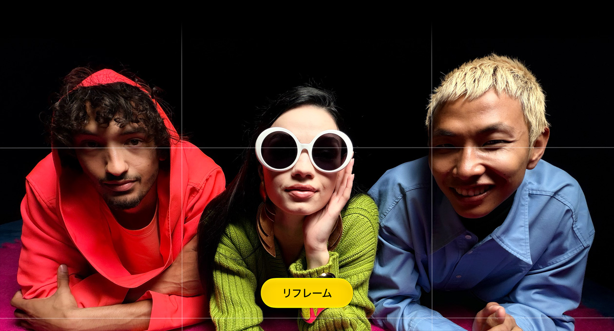 カメラを見つめる3人の人物を撮影した明るい色合いのクローズアップ写真。「Reframe」というボタンが表示されている