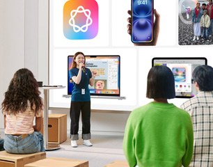 Apple Storeのスタッフがマイクを持って大きなスクリーンの前に立ち、参加者に向かって話している