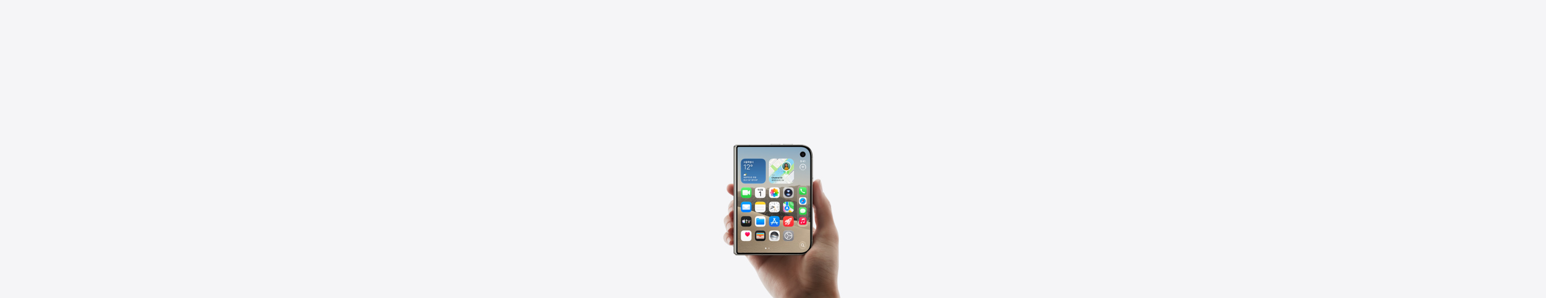 iPhone Duo 스타 화이트 색상을 닫힌 상태에서 한 손으로 잡은 모습. 외부 디스플레이에 앱과 위젯들이 표시된 홈 화면이 보입니다.