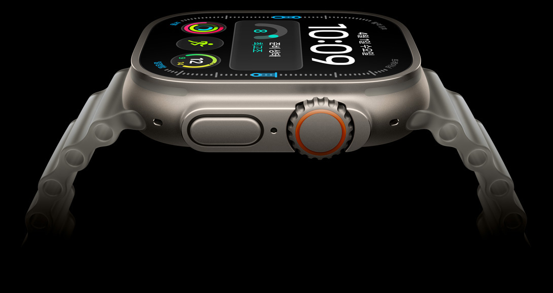 Apple Watch Ultra 4, 내추럴 색상 티타늄 케이스, 디지털 시계 페이스에 준비 상태, 심박수, 운동 및 자외선 지수 등의 컴플리케이션, 오른쪽 옆면 외관에 Digital Crown, 돌출된 측면 버튼, 트랜스루센트 그레이 색상 오션 밴드의 모습이 보입니다.