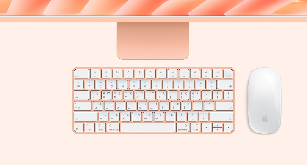 오렌지 색상 iMac을 위에서 바라본 모습. Magic Mouse 및 Touch ID 탑재형 Magic Keyboard가 함께 있습니다.