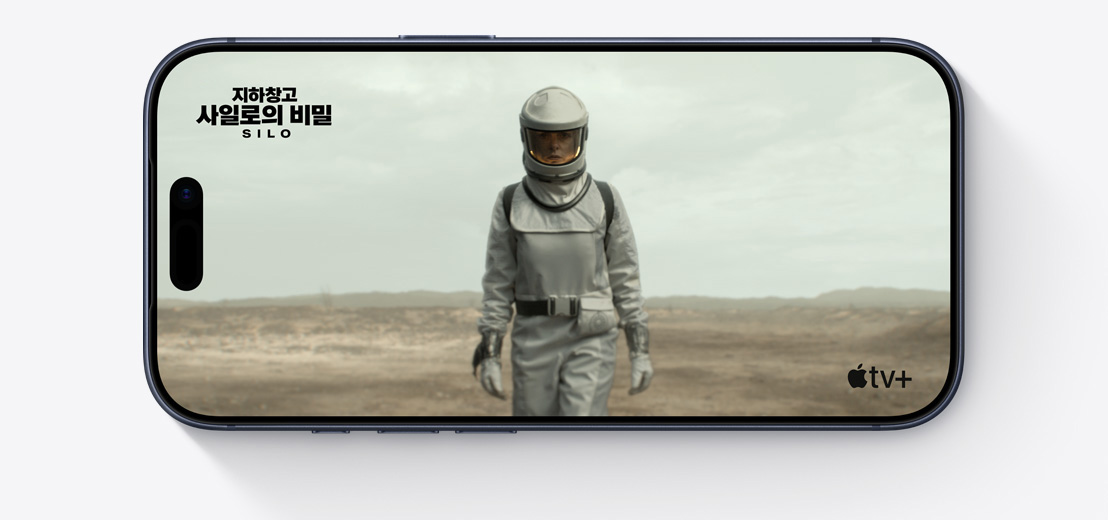 Apple TV+ 시리즈 ‘지하창고 사일로의 비밀’ - SILO 한 장면이 표시되어 있는 가로 방향 iPhone 앞면