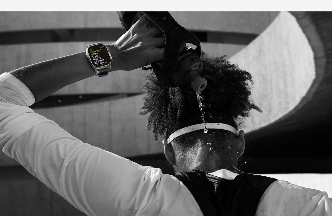 Apple Watch Ultra 2를 착용하고 경기에 참가 중인 운동 선수가 뒷목에 물을 뿌리는 모습.