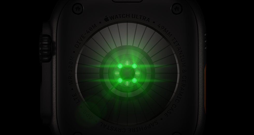 Apple Watch Ultra 4 aizmugure, titāna ietvars, melns, vairāki apaļi sensori ar zaļi mirdzošām LED gaismām