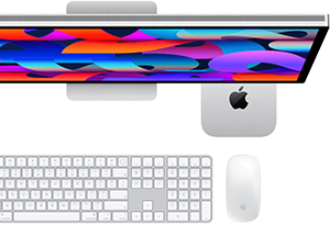 Mac mini novietots zem Studio Display, Magic Keyboard tastatūra ar cipartastatūru, Magic Mouse pele