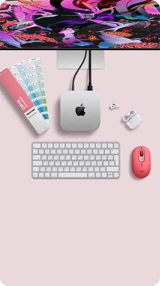 جهاز Mac mini، الجهة العلوية، ألومنيوم فضي، زوايا مدورة، شعار Apple باللون الأسود اللامع في الوسط، متصل بسلك، شاشة Studio Display تظهر بشكل جزئي في الأعلى، سماعات AirPods 4، مفتوحة، عينات ألوان Pantone، ولوحة مفاتيح رقمية وماوس