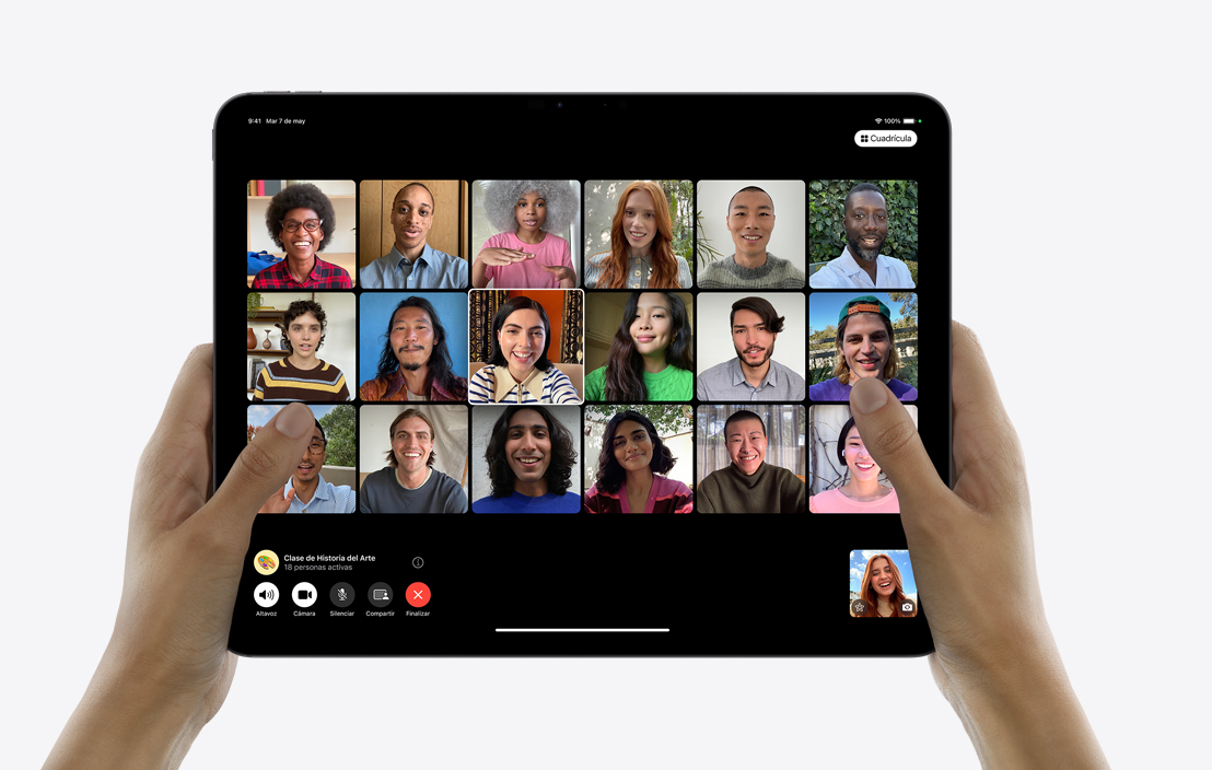 Dos manos sostienen un iPad Pro que muestra una llamada de FaceTime en Grupo.