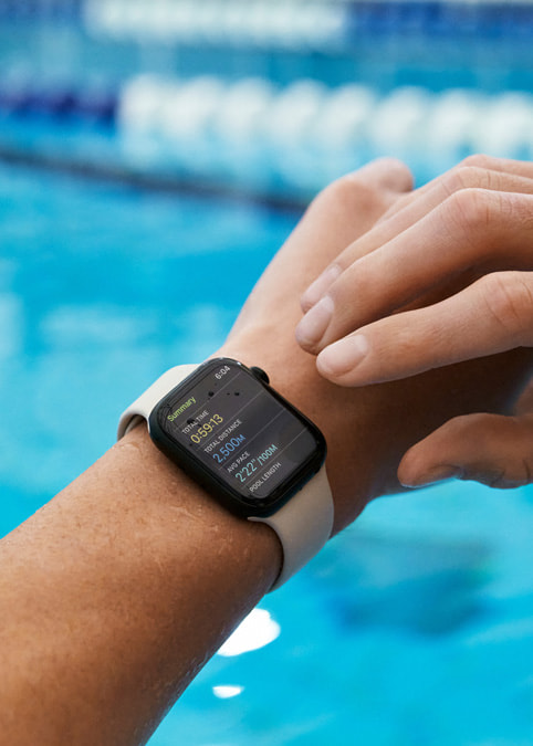 Closeup of swimmer using the native Workout app on Apple Watch to track metrics.